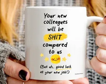 Hands holding a white mug reading “Your new colleagues will be shit compared to us (But uh.. good luck at your new job!)”