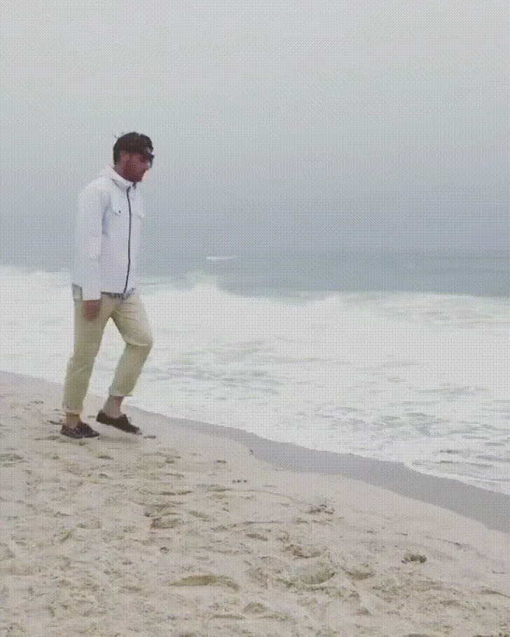 Animated gif of a person riding an escalator down toward a sunny beach