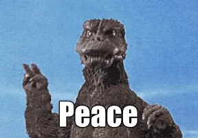 Animated gif of a Godzilla figure raising a hand against a blue sky, caption “Peace”