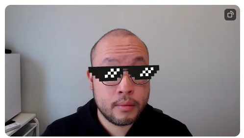 Man on a Zoom video feed wearing a pixelated deal-with-it sunglasses filter