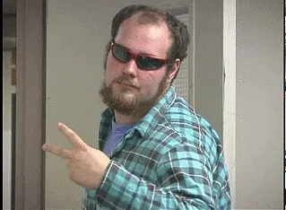 Animated gif of a bearded man in a plaid shirt and dark sunglasses pointing finger guns
