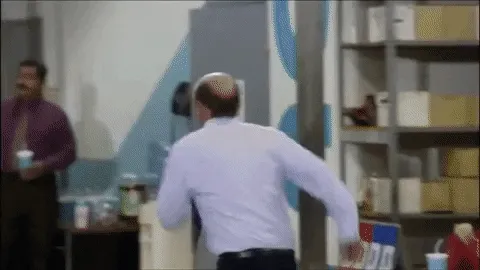 Animated gif of an office worker in a shirt dashing out through the office in a hurry