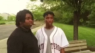 Animated gif of two young men outside, one giving a farewell nod to the other