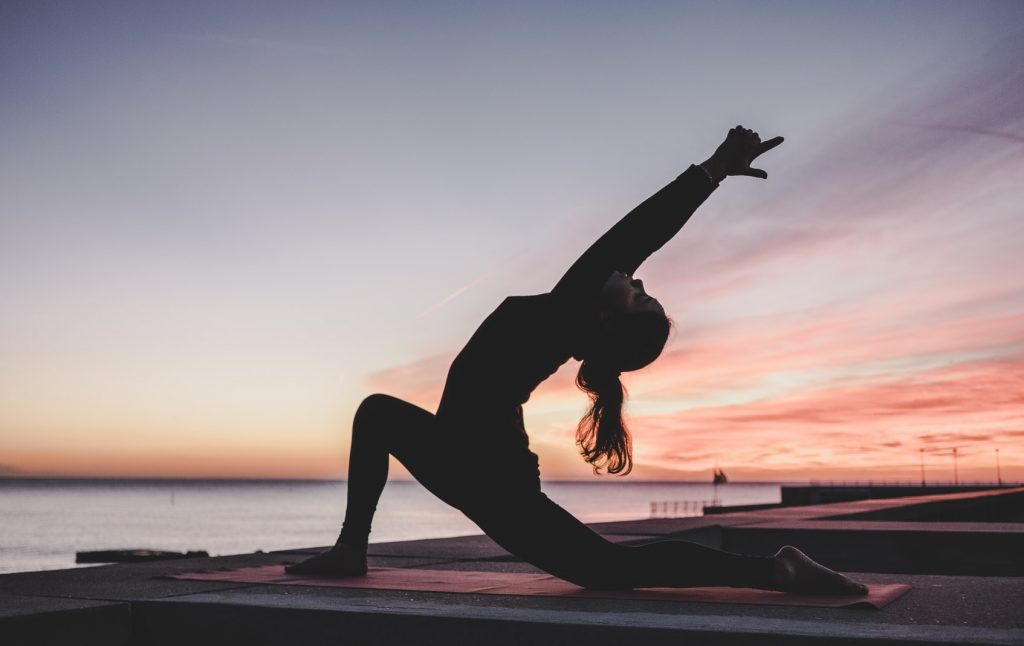 woman on beach doing yoga