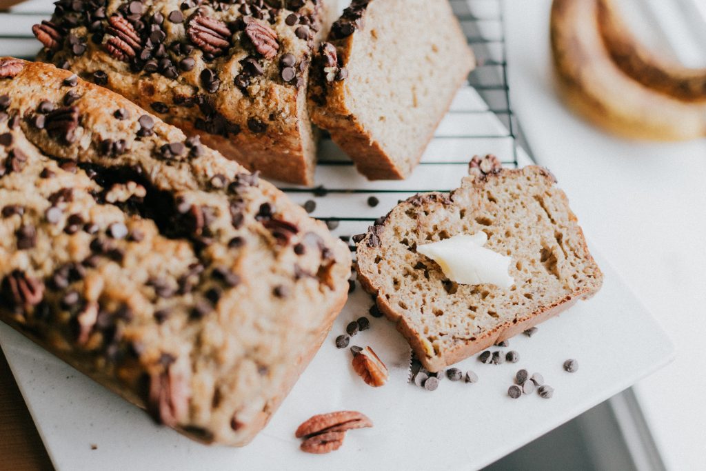 loaf of banana bread, a slice with a pat of butter